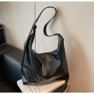 Detail of black large hobo bag with adjustable strap and smooth leather texture