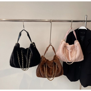 Detail of plush tote bag showing faux fur texture, chain strap, and color options