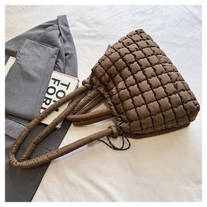 Gros plan du sac fourre-tout matelassé marron avec texture de bulle et poignée rembourrée
