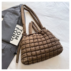 Gros plan du sac fourre-tout matelassé marron foncé avec texture froissée et poignée