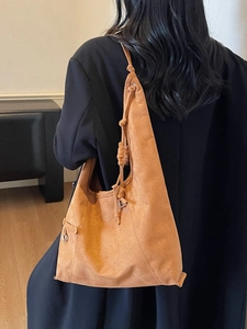 Large caramel suede tote bag with knot shoulder strap detail worn by a model