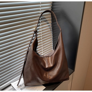 Detailed close-up of dark coffee hobo bag with vintage pleated leather texture and soft strap