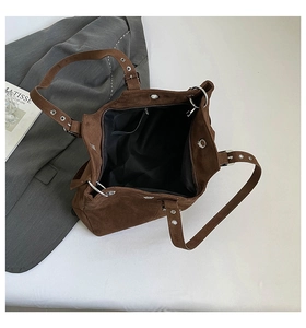 Detail view of large brown suede tote bag featuring black lining and inner zipper pocket