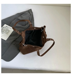 Top view of spacious interior of dark brown suede tote bag with black lining and silver studs