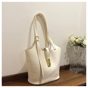 Detail of minimalist beige tote bag with textured faux leather and golden metal clasp