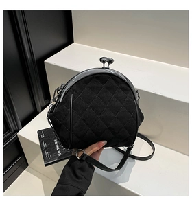 Detail of black quilted velvet crossbody bag featuring a vintage metal kiss-lock closure