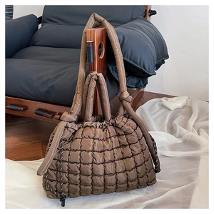 Vue détaillée du sac cabas matelassé marron foncé avec texture bouffante sur support
