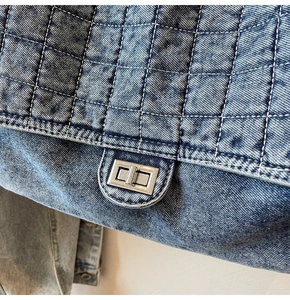 Gros plan du sac en denim vintage bleu avec matelassage et fermoir tournant en métal argenté