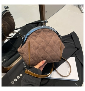 Close-up of brown quilted suede kiss-lock bag with retro silver metal frame and chain