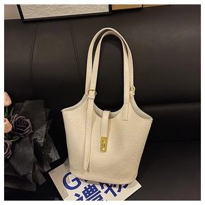 Close-up of cream-colored tote bag with pleated PU leather texture and gold metal twist lock