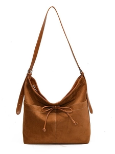 Sac bandoulière en suédine marron avec nœud décoratif et surpiqûres blanches sur fond blanc