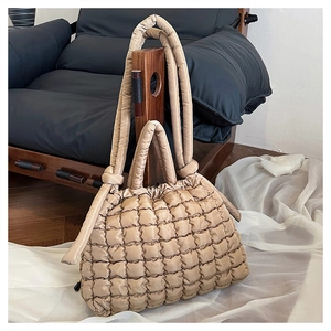 Détail de la texture matelassée et de la poignée rembourrée de ce sac fourre-tout marron