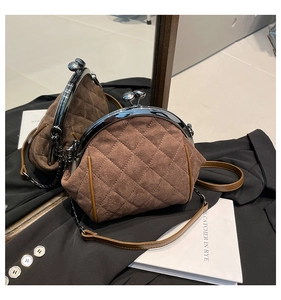 Detail of brown quilted suede bag showing retro metal ball clasp and chain strap