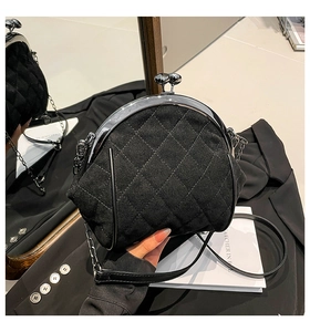 Close-up of quilted black velvet crossbody bag with silver metal frame and chain strap