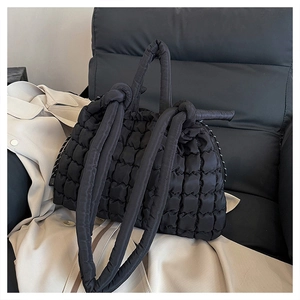 Détail du sac cabas matelassé noir avec poignées nouées et tissu texturé en relief