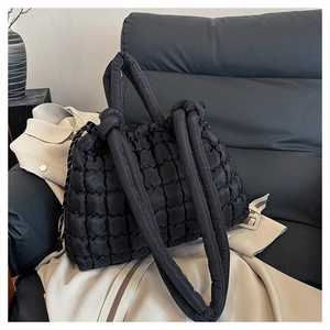 Détail du sac fourre-tout noir matelassé avec poignée nouée et motif en damier