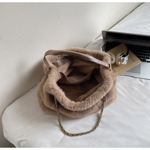 Detail view of brown faux fur shoulder bag interior with chain strap and soft plush texture