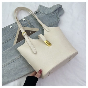 Close-up of beige tote bag featuring embossed FF monogram patterns and golden buckles