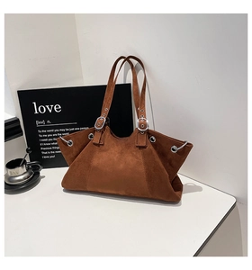 Detailed shot of dark brown suede tote bag featuring silver eyelets and metal ring accents
