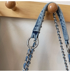 Détail de la bandoulière en denim et chaîne argentée avec grands anneaux métalliques