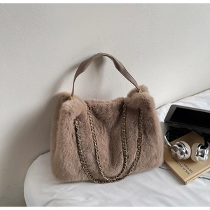 Detailed macro view of plush brown faux fur tote bag with metal chain and leather handle