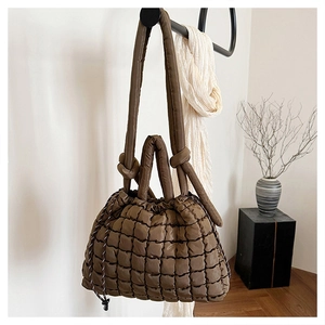 Détail du sac fourre-tout matelassé marron foncé avec tissu texturé et bandoulière