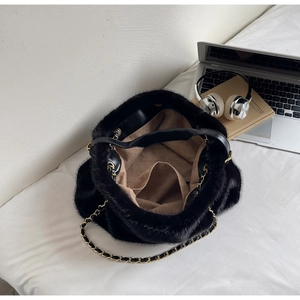 Detail view of the black faux fur tote interior showing the lining and gold chain strap