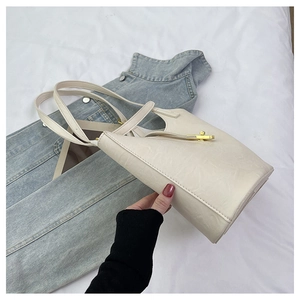 Detailed macro view of cream PU leather tote bag with elegant golden twist lock buckle