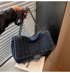 Gros plan sur sac en jean bleu foncé avec matelassage carré et bandoulière en chaîne