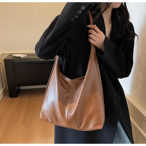 Detail of vintage brown Hobo shoulder bag with vertical stitching on textured soft leather