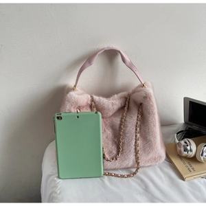 Detailed view of pink faux fur handbag with leather handle and gold chain strap
