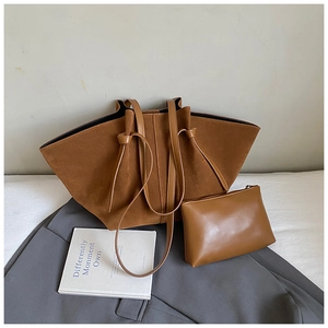 Detail of caramel suede tote bag and matching zipper pouch on neutral lifestyle background