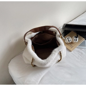 Detail of white faux fur tote bag with brown leather handles and spacious inner lining