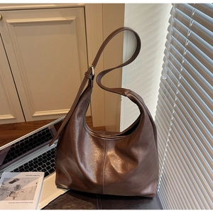 Detail of dark brown leather tote showing vintage textured finish and adjustable strap