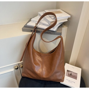 Detail of soft brown PU leather hobo bag showing natural texture and minimalist stitching