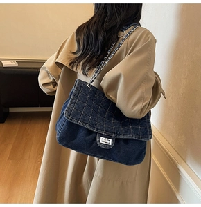 Detail of blue denim shoulder bag with silver turn-lock and quilted diamond stitching