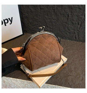 Close-up of retro dark brown quilted handbag with silver kiss-lock and metal chain