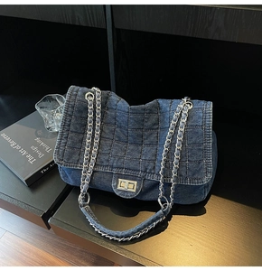 Close-up of vintage denim quilted bag with silver twist lock and woven chain strap detail