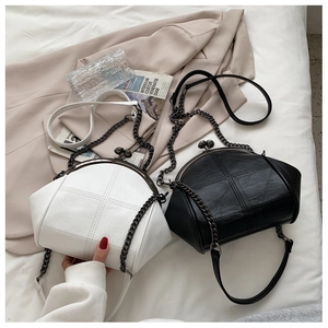 Detail of quilted leather shell bags with metal clasps and chain straps in black and white
