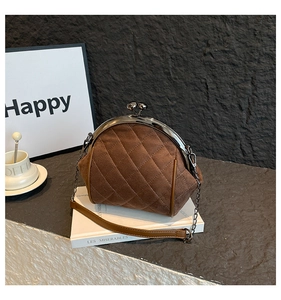 Detail of vintage brown quilted suede handbag with classic metal kiss-lock closure