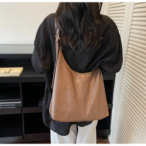 Detailed view of the brown leather tote bag with soft texture and adjustable shoulder strap