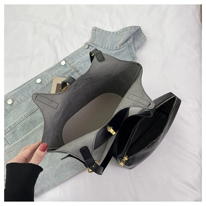 Close-up of black leather tote bag interior with inner pouch and gold hardware