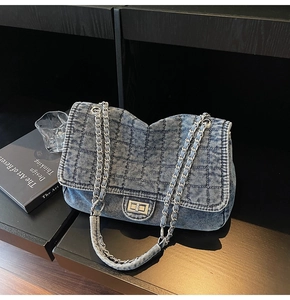 Close-up of vintage blue denim shoulder bag with quilted pattern and silver chain strap