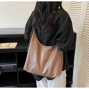 Brown leather Hobo bag worn over the shoulder showing detailed texture and stitching