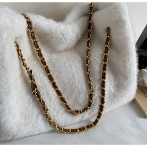 Detail of white faux fur tote bag with golden metal and brown leather chain strap