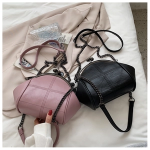 Detail of quilted leather shell bags with metal chain straps in pink and black colors