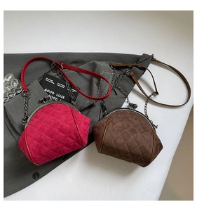 Detail of quilted suede crossbody bags with metal frame closure and chain strap