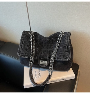 Close-up of quilted denim chain bag with silver twist lock and grey diamond stitching