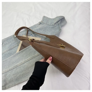 Detailed close-up of dark brown lychee pattern leather tote with adjustable shoulder strap