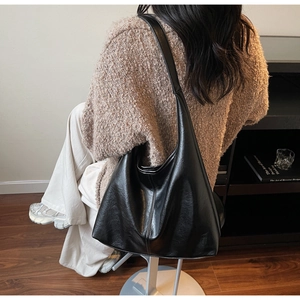 Detailed back view of a black large-capacity soft leather tote bag on model shoulder